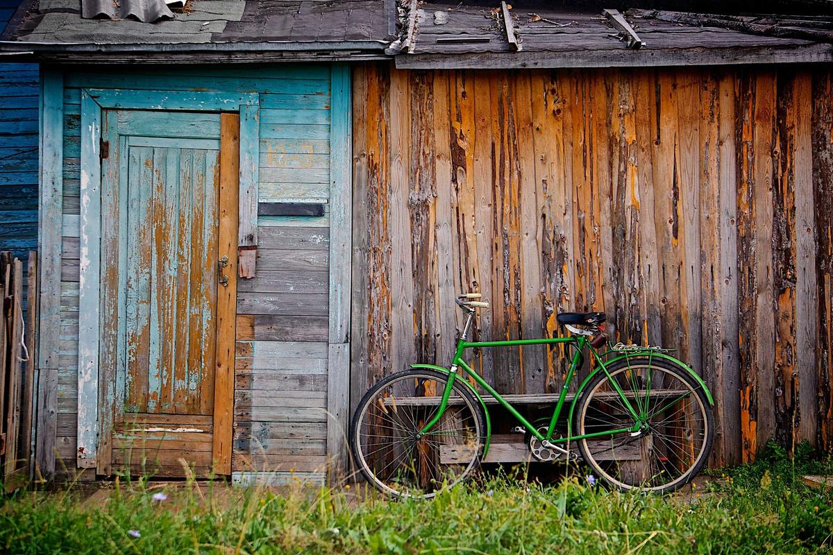 Smart Cover Travel Insurance outdoor weekend getaway showing a green bicycle beside a rustic cabin