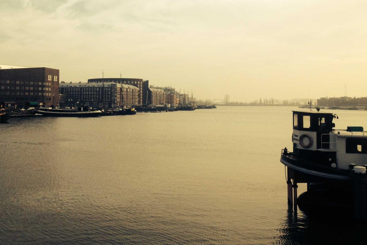 Business Travel Booking: harbor waterfront with historic brick warehouses and a moored boat